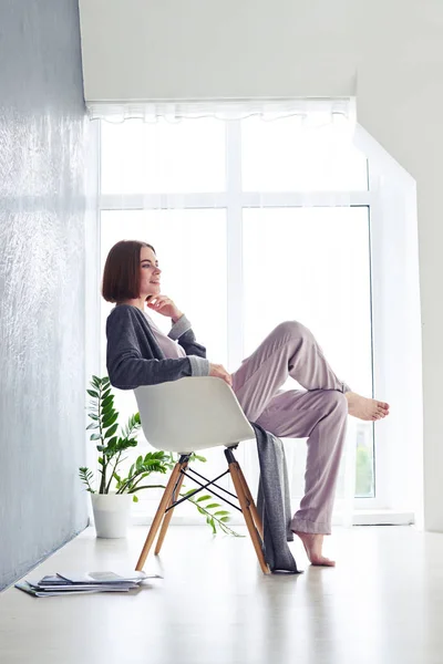 Lovely girl enjoying rest and sitting on armchair — Stock Photo, Image