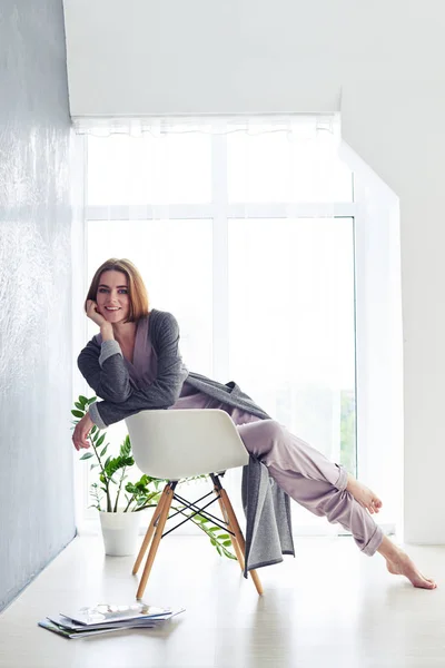 Senhora graciosa em pijama desfrutando de descanso na poltrona — Fotografia de Stock