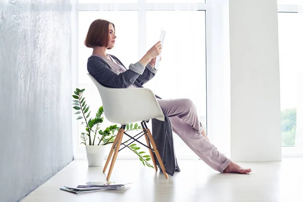 Maravillosa revista de lectura de castañas en sillón —  Fotos de Stock