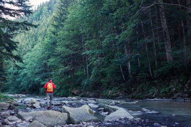 Uzun yürüyüşe çıkan kimse ile dağ nehir boyunca hiking sırt çantası