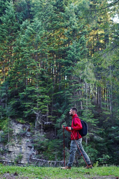 Jovem com postes de caminhada nas montanhas — Fotografia de Stock