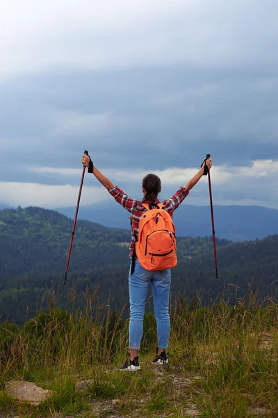 Young female hiker with poles outstretched hands — Stock Photo, Image