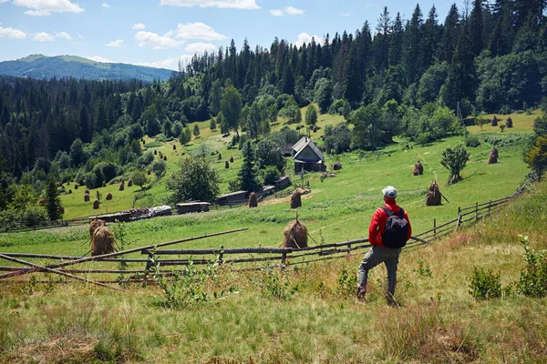 Homem observando aldeia em montanhas — Fotografia de Stock