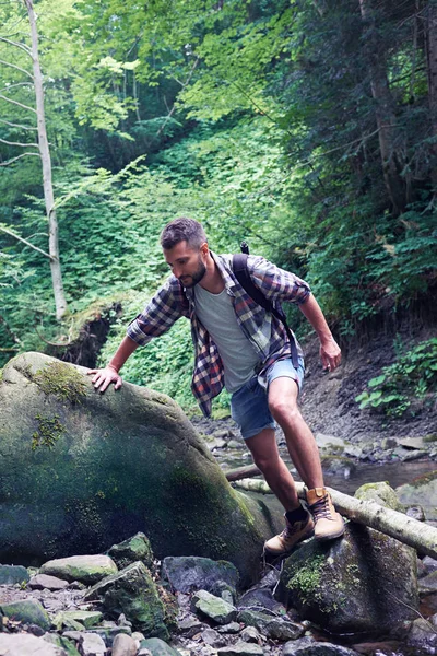 Man climbing rocks on mountains river — Stock Photo, Image