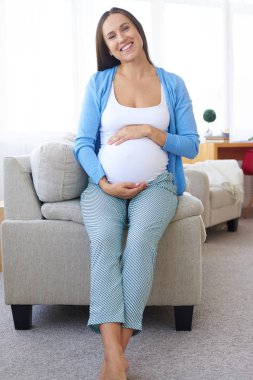 Mutlu bekleyen oturma odasında kanepede oturan 