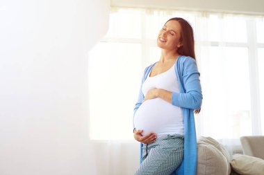 Hamile kadının evde sıcak günbatımı ışığı 