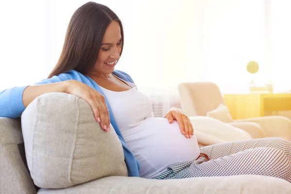 Carinhoso mãe amorosa olhando para a barriga — Fotografia de Stock