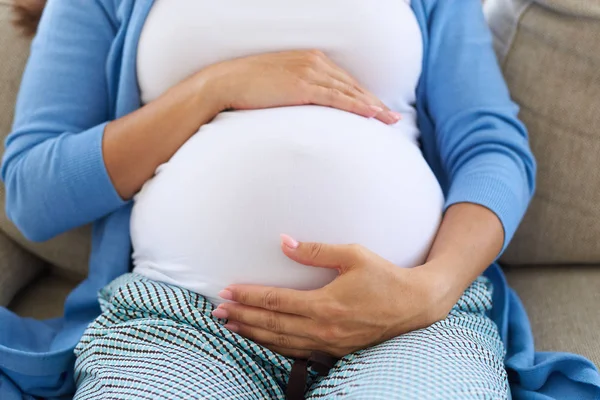 Kobieta w trzecim trymestrze ciąży dotyka jej brzuch — Zdjęcie stockowe