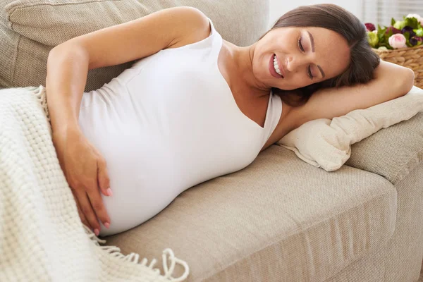 Szczęśliwy ciąży brzuch ogarnięcie na kanapie — Zdjęcie stockowe