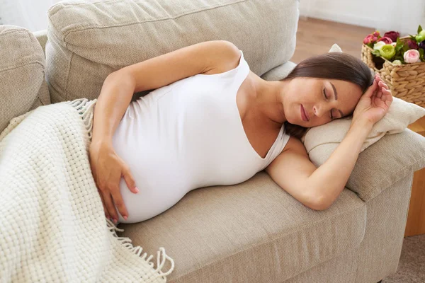 Tranquila mujer embarazada durmiendo en el sofá — Foto de Stock