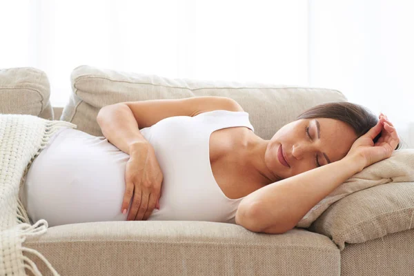 Schlafende schwangere Frau auf Sofa — Stockfoto