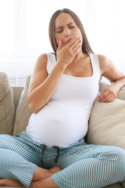 Hamile kadın kanepede otururken esneme bitkin 