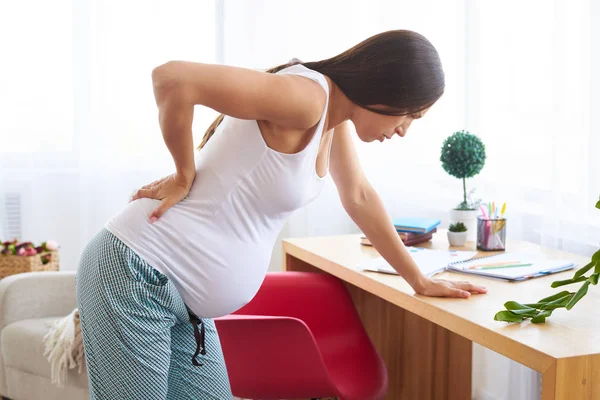 Jonge zwangere vrouw die lijden aan rugpijn — Stockfoto