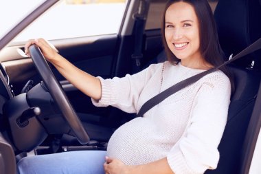 Sürücü koltuğu üzerinde poz göbek üzerinde el ile mutlu gelecekte anne 