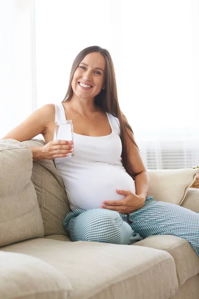 Pregnant woman holding a glass of water — Stock Photo, Image
