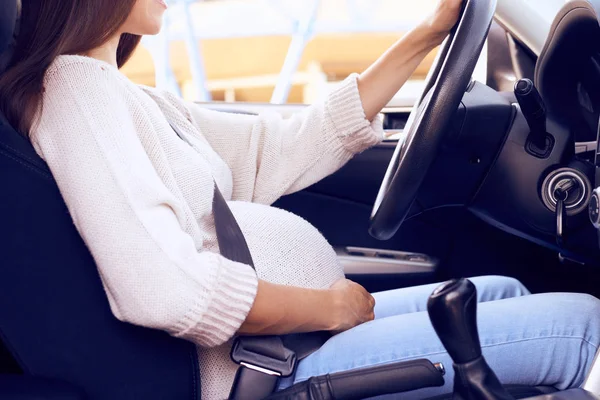 Mujer embarazada joven abrochado coche de conducción — Foto de Stock