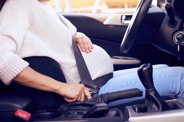 Mujer embarazada conduciendo el coche, abotonada con cinturón de seguridad —  Fotos de Stock