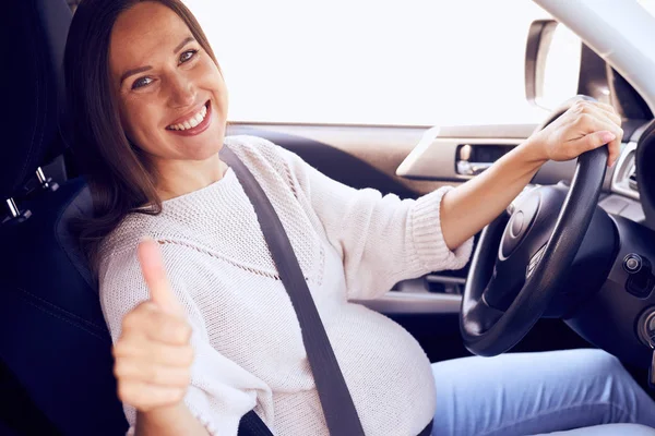 Pregnant woman showing thumb up for safety on road — Stock Photo, Image