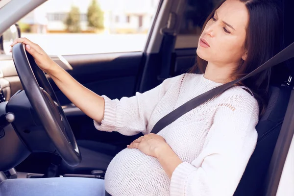 Young pregnant woman behind the steering wheel feeling bad — Stock Photo, Image