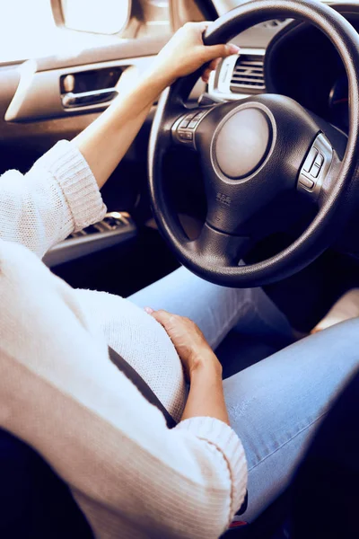 High angle of pregnant woman buckled up at wheel — Stock Photo, Image