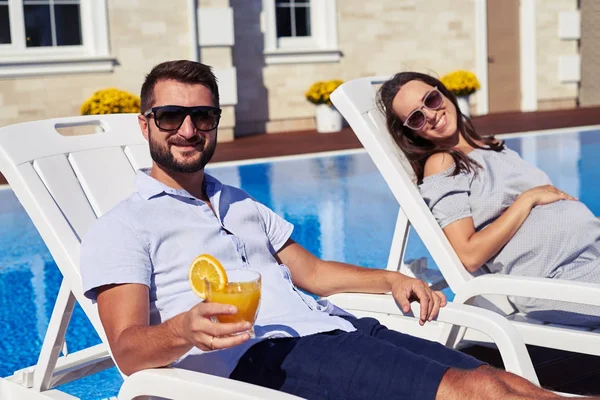 Paar genießt Sonne in moderner Residenz in Poolnähe — Stockfoto