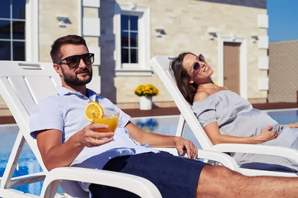 Zufriedenes Paar entspannt vor modernem Haus mit Pool — Stockfoto