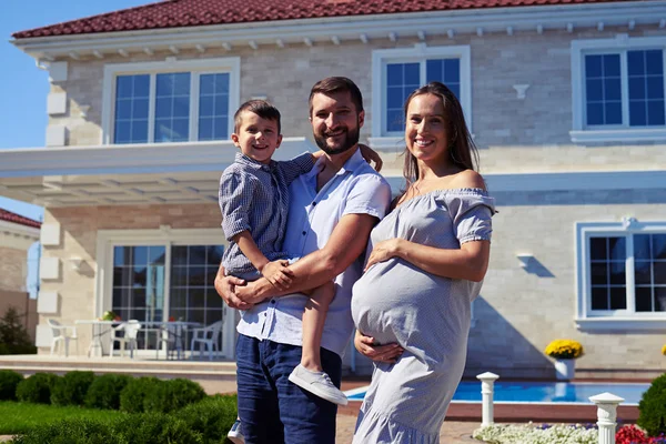Glückliche Familie steht vor neuem modernen Haus — Stockfoto