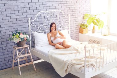 Sevgi hamile kadın yatak odasında rahatlatıcı 