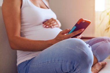 Kadın hamile karnıma dokunmaktan ve evde telefon kullanarak eller 