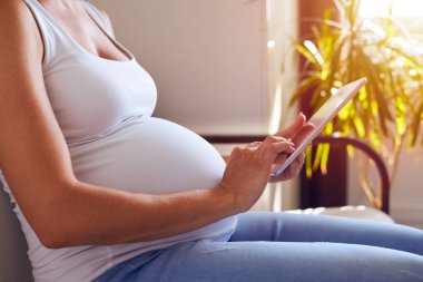 Gelecekte anne arka plan üzerinde güneş ışınları ile tablet kullanma 