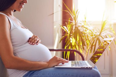 Touchpad laptop kullanan hamile kadın 