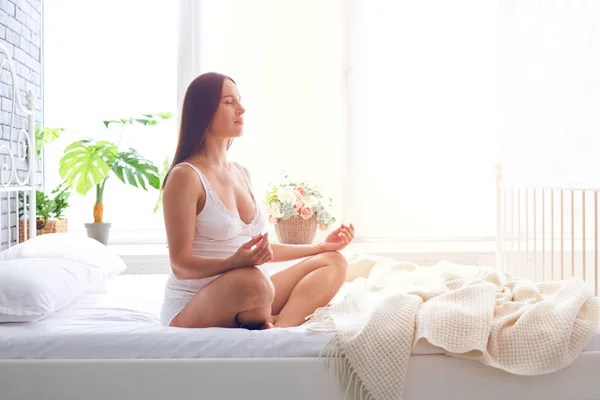 Concentrated pregnant woman meditating in bedroom — Stock Photo, Image