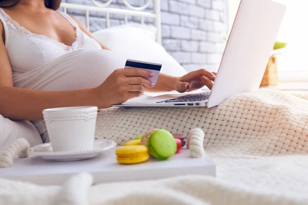 Pregnant woman shopping online in bedroom — Stock Photo, Image
