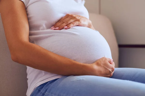 Жінка обіймає вагітний живіт — стокове фото