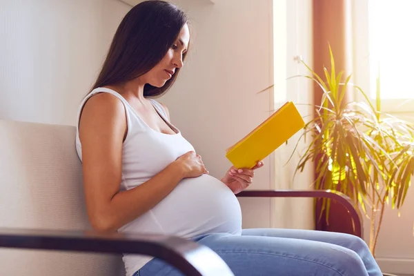 Futura madre leyendo libro de embarazo — Foto de Stock
