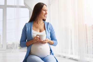 Pencerenin yanında otururken kadın çay içme gülümseyen 