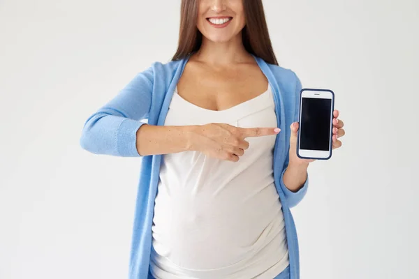 Pregnant woman pointing at smartphone with black screen — Stock Photo, Image
