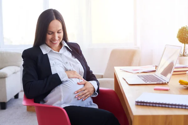 Empresaria embarazada sentada en el lugar de trabajo — Foto de Stock