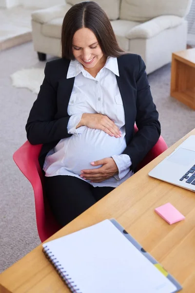 Empresaria embarazada sentada en el lugar de trabajo — Foto de Stock