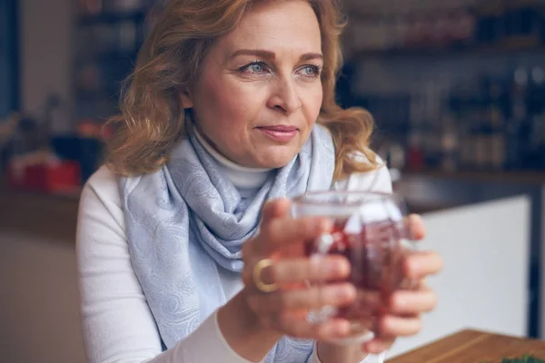 Reife Frau hält heiße Tasse Tee an warme Hände — Stockfoto