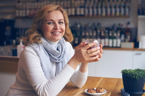 Mujer madura cándida disfrutando de una taza de té — Foto de Stock