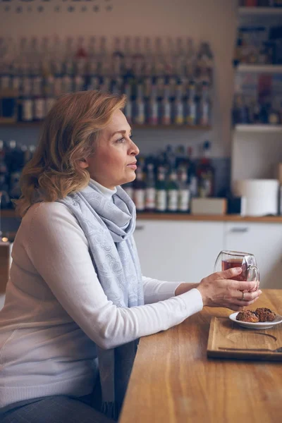 Träumende reife Frau mit einer Tasse Tee sitzt im Café — Stockfoto