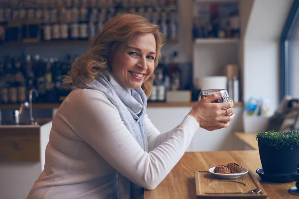 Blij volwassen vrouw die lacht op camera tijdens theepauze — Stockfoto