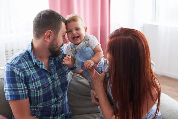 Jeune couple avec jolie fille riant sur canapé — Photo