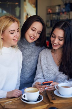 Bir şey için iki arkadaş smartphone üzerinde gösterilen kadın