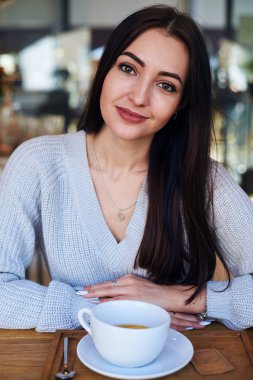 Yalnız kafede oturan genç büyüleyici kadın 