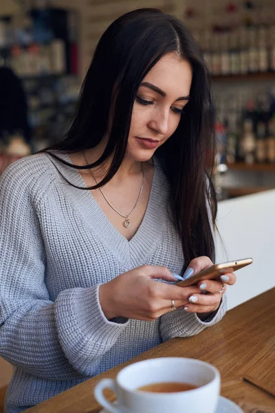 Mujer bastante caucásica usando el teléfono en la cafetería —  Fotos de Stock