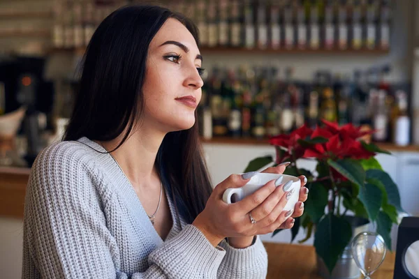 Dromerige meisje houdt van kopje koffie een café — Stockfoto