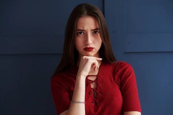 Ernstes Mädchen mit roten Lippen posiert vor Hintergrund — Stockfoto