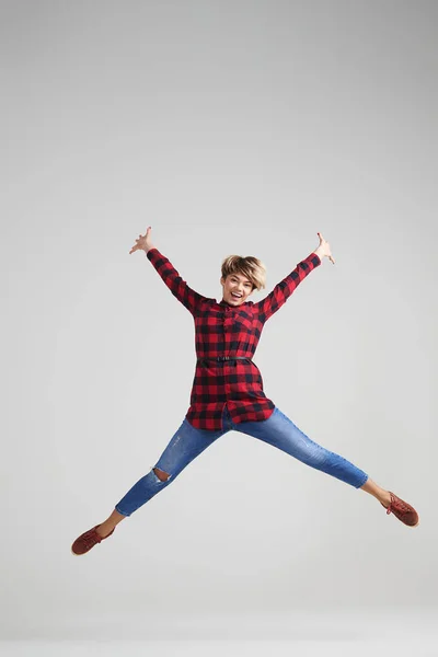 Positive Frau springt vor Aufregung im Studio — Stockfoto
